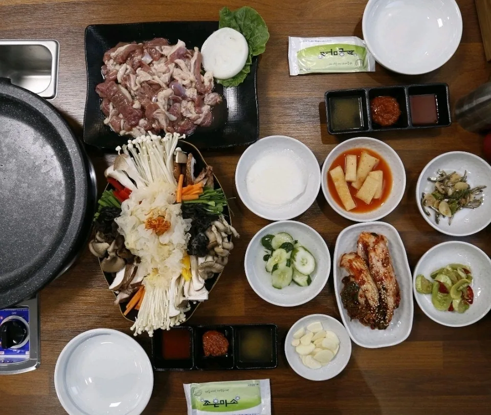 다양한 버섯과 신선한 생오리고기가 차려진 한 상 차림